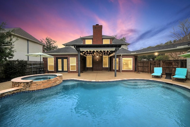 pool at dusk featuring french doors, a patio, and fence