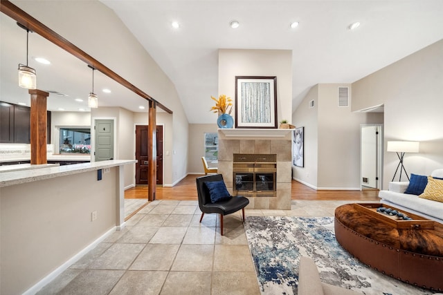 living area with a tile fireplace, visible vents, and recessed lighting