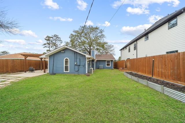 rear view of house featuring a vegetable garden, a chimney, a patio, a lawn, and a fenced backyard