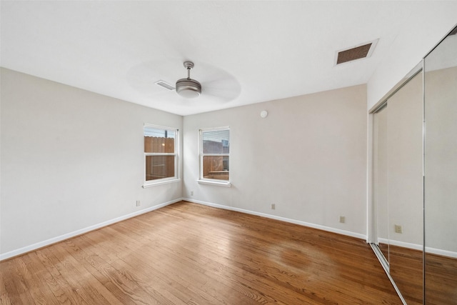 unfurnished bedroom featuring baseboards, visible vents, and wood finished floors