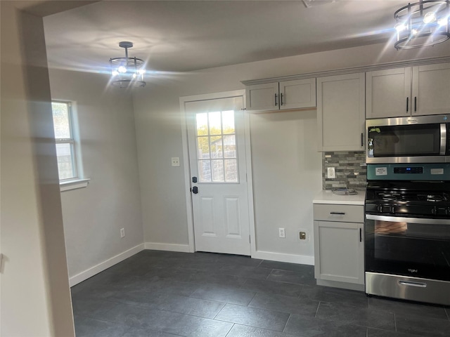 kitchen featuring stainless steel appliances, light countertops, a wealth of natural light, and decorative backsplash