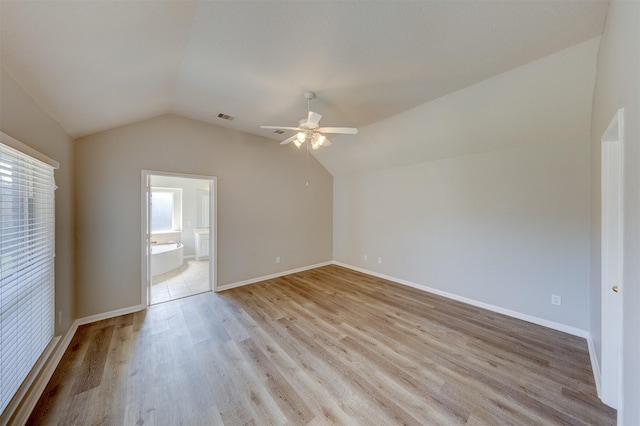 empty room with ceiling fan, lofted ceiling, light wood-style flooring, visible vents, and baseboards