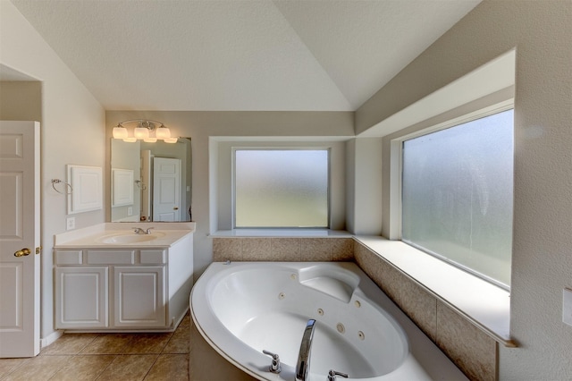 full bath featuring a tub with jets, tile patterned floors, vaulted ceiling, vanity, and a healthy amount of sunlight