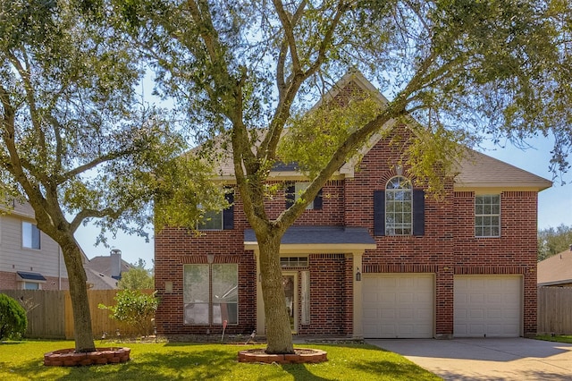 traditional-style home featuring a garage, concrete driveway, brick siding, and fence