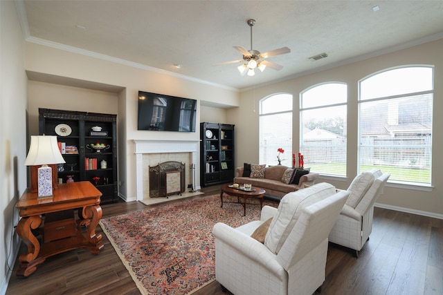 living room featuring visible vents, baseboards, ornamental molding, a fireplace, and dark wood-style floors