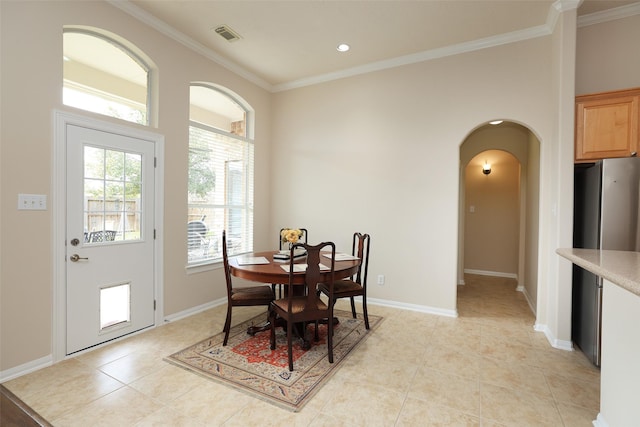 dining area with visible vents, ornamental molding, arched walkways, light tile patterned floors, and baseboards