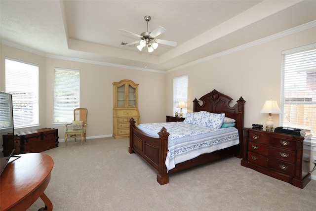 bedroom featuring multiple windows, a raised ceiling, light carpet, and ornamental molding