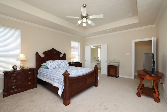 bedroom with baseboards, a tray ceiling, ensuite bath, ceiling fan, and light carpet