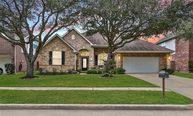 view of front of property with a yard, an attached garage, a shingled roof, concrete driveway, and brick siding