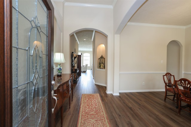 entrance foyer featuring dark wood finished floors, arched walkways, crown molding, and baseboards