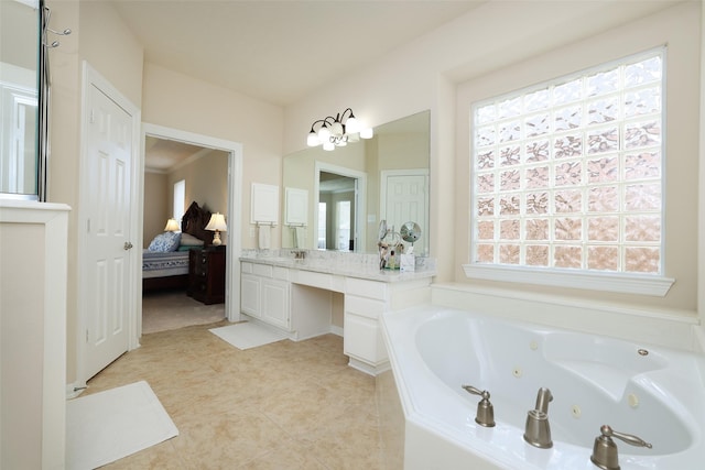 bathroom with a healthy amount of sunlight, ensuite bathroom, a jetted tub, and vanity