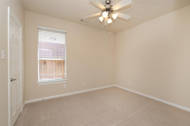 unfurnished room featuring visible vents, light colored carpet, baseboards, and a ceiling fan