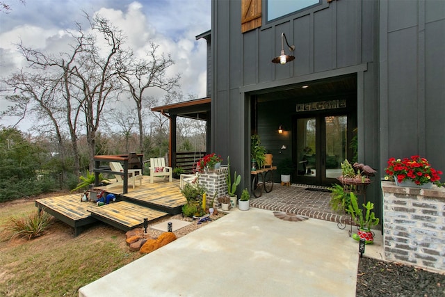 entrance to property with board and batten siding and a wooden deck