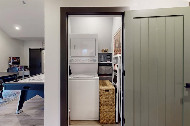 washroom with laundry area, light wood-style flooring, and stacked washer and clothes dryer