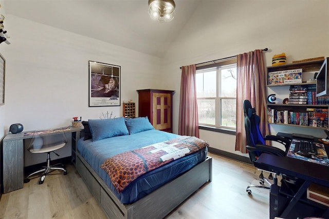 bedroom with vaulted ceiling, baseboards, and wood finished floors