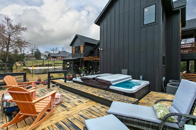 wooden terrace featuring hot tub deck surround