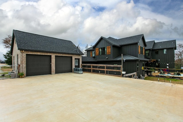 view of property exterior featuring a shingled roof, board and batten siding, and brick siding