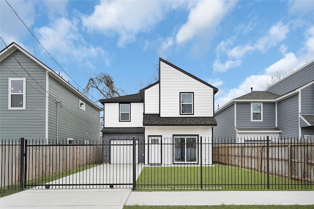 exterior space with driveway, a fenced front yard, and a yard