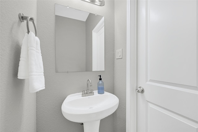 bathroom with a textured wall and a sink