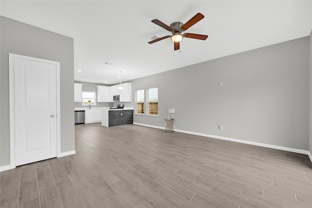 unfurnished living room with recessed lighting, visible vents, a ceiling fan, baseboards, and light wood finished floors