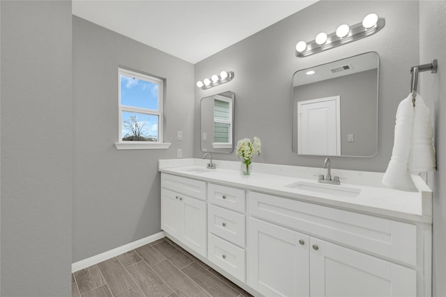 full bathroom with visible vents, a sink, baseboards, and double vanity