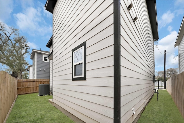 view of property exterior with central AC unit, a lawn, and a fenced backyard