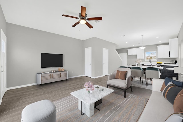 living room featuring dark wood-style floors, baseboards, a ceiling fan, and recessed lighting