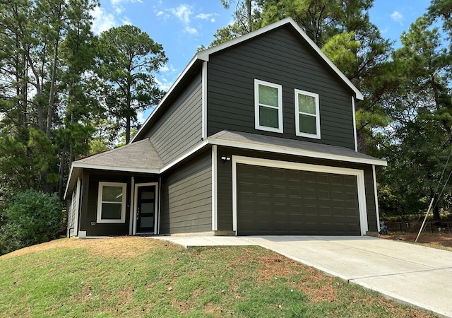 view of front facade featuring a garage, concrete driveway, and a front yard