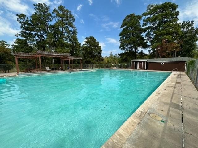 pool featuring fence and a pergola