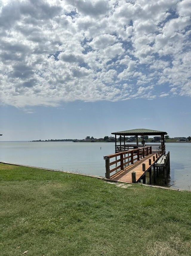 dock area with a water view and a yard