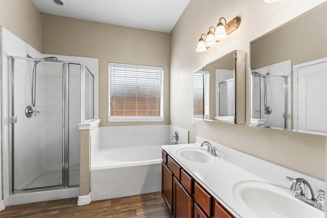 full bath with a sink, a shower stall, and wood finished floors