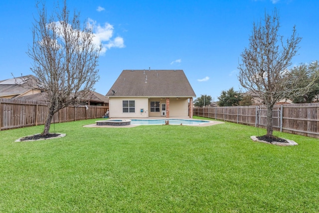 back of property with a fenced backyard, a fenced in pool, and a lawn