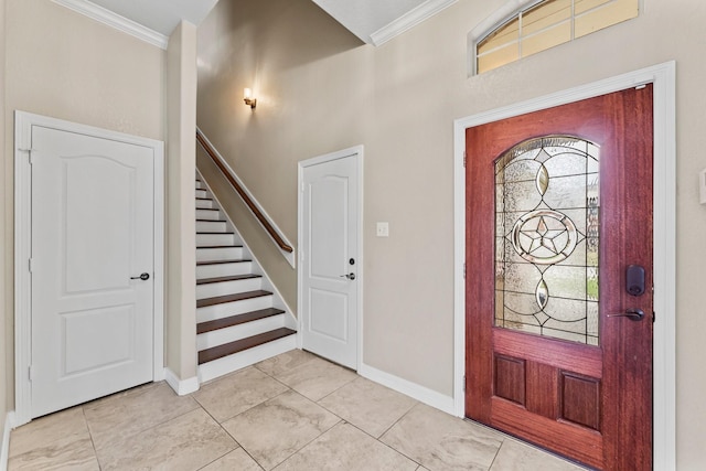 foyer with ornamental molding, baseboards, and stairway
