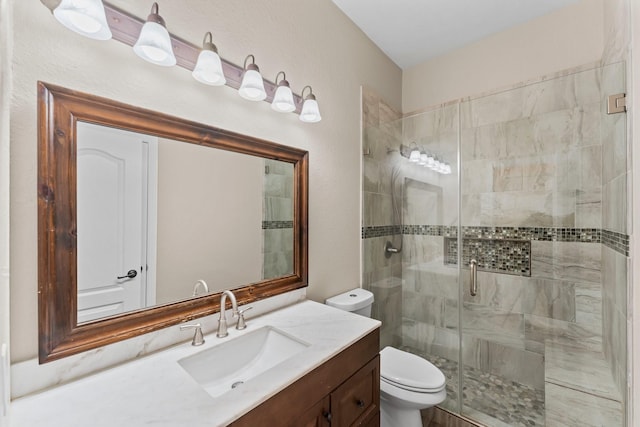 full bath featuring toilet, a stall shower, and vanity