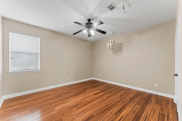 unfurnished room with baseboards, visible vents, a ceiling fan, and hardwood / wood-style flooring