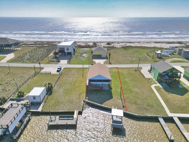 birds eye view of property featuring a water view and a beach view