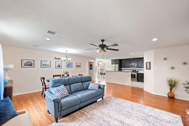 1009 Canadian St, Houston, TX 77009 - living room featuring baseboards, visible vents, light wood-type flooring, and ceiling fan with notable chandelier