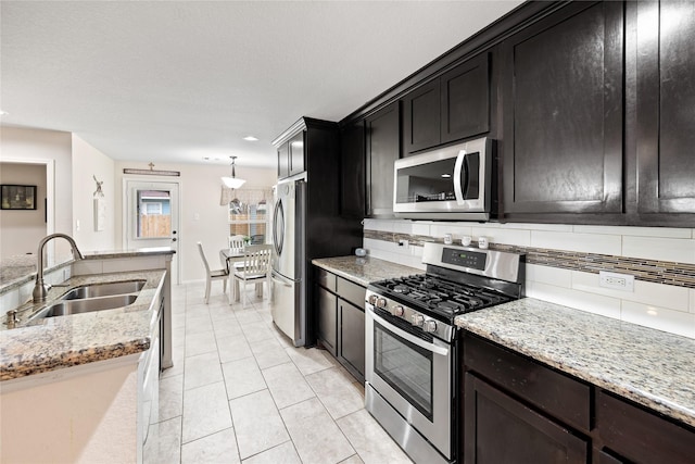 1009 Canadian St, Houston, TX 77009 - kitchen featuring light stone counters, a sink, backsplash, appliances with stainless steel finishes, and light tile patterned floors