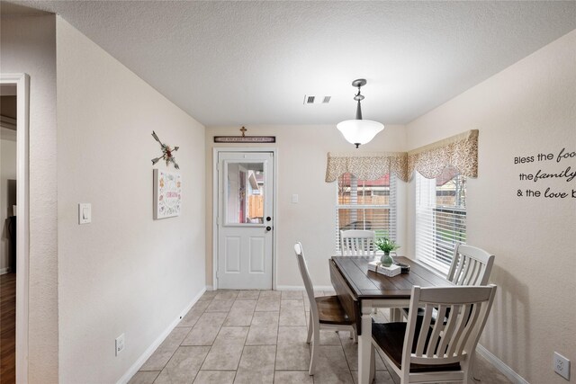1009 Canadian St, Houston, TX 77009 - dining space with light tile patterned flooring, baseboards, visible vents, and a textured ceiling
