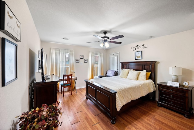 1009 Canadian St, Houston, TX 77009 - bedroom with a ceiling fan, a textured ceiling, baseboards, visible vents, and light wood-style floors