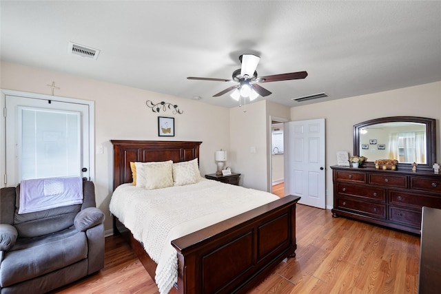 bedroom featuring light wood-style flooring, visible vents, and a ceiling fan