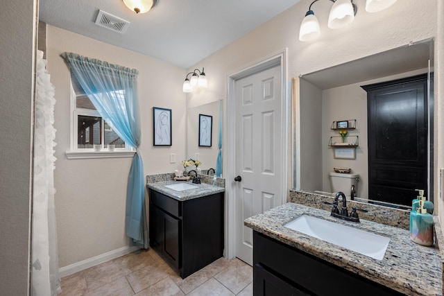 full bath featuring two vanities, a sink, visible vents, and tile patterned floors