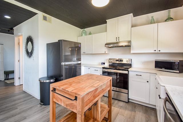 kitchen featuring stainless steel appliances, light countertops, white cabinetry, and under cabinet range hood