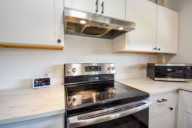 kitchen with under cabinet range hood, white cabinetry, and stainless steel appliances