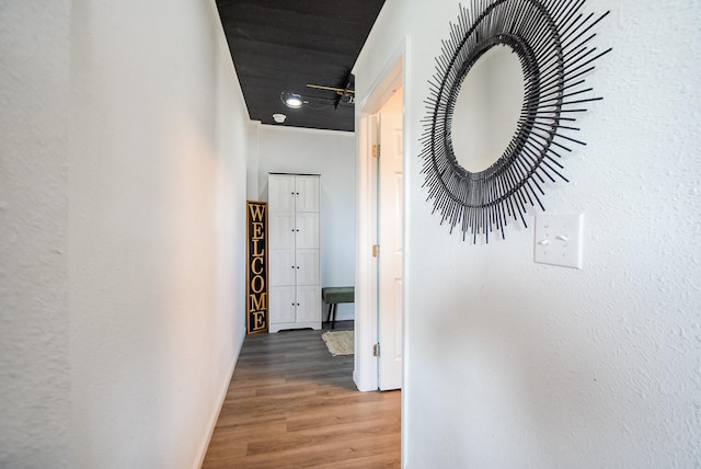 hall featuring wood finished floors and baseboards