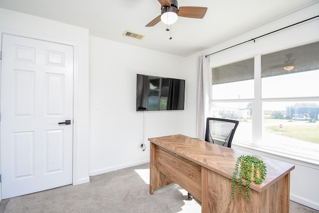 office featuring light colored carpet, ceiling fan, visible vents, and baseboards