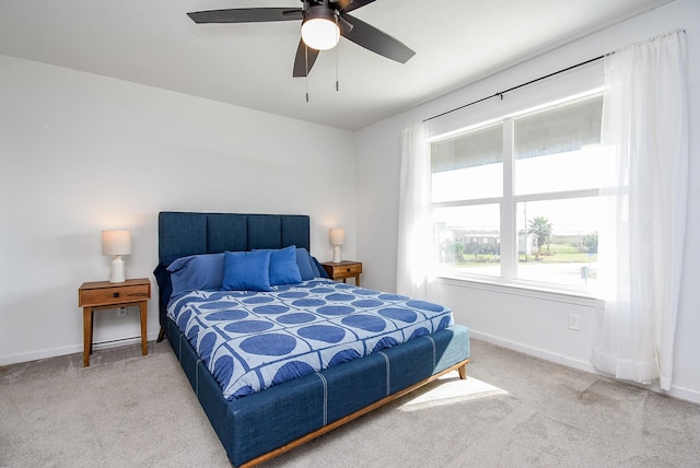 bedroom featuring baseboards, a ceiling fan, and light colored carpet