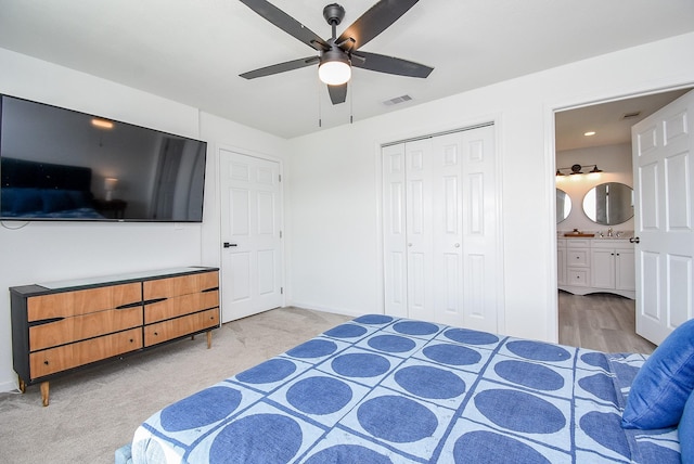 bedroom with ceiling fan, light colored carpet, visible vents, baseboards, and a closet