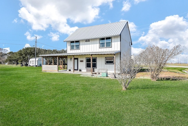 rear view of property featuring board and batten siding, metal roof, and a lawn