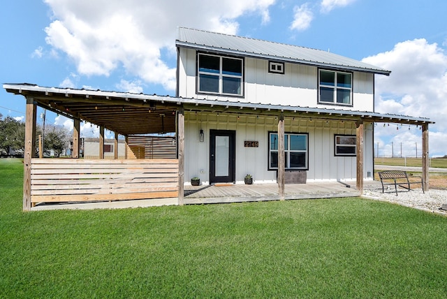 rear view of house with a lawn, metal roof, and board and batten siding